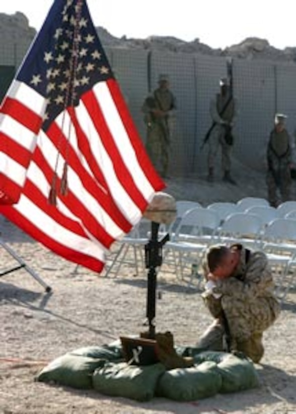 A Marine with Combat Logistics Regiment-15, 1st Marine Logistics Group (Fwd) pays his final respects to fallen comrade Pfc. Vincent M. Frassetto, a fire-direction controlman with Military Police Company, CLR-15. Frassetto was fatally wounded by an improvised explosive device attack while on a vehicle patrol to Al Asad, Iraq. Frassetto, a 21-year old from Toms River, N.J., is remembered most for his upbeat personality and contagious smile. ?Looking back, there isn?t a time I can remember that he wasn?t smiling? He picked us up, he helped us,? said Lance Cpl. Christopher P. Manuel, an artillery specialist with 1st Battalion, 10th Marines. Frassetto?s awards include the National Defense Service and Global War on Terrorism medals.