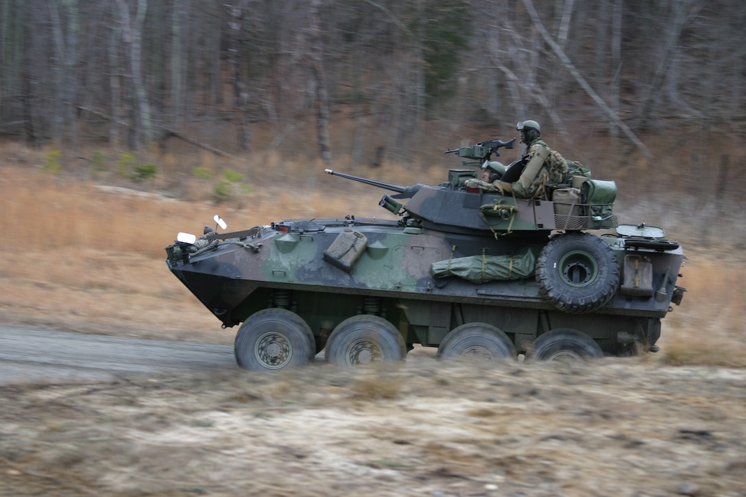 A Light Armored Vehicle from BLT 1/8 speeds to its firing position while Col. Ron Johnson, Commanding Officer of the 24th MEU and U.S. Navy Capt. Sinclair Harris, Commadore of the Iwo Jima Expeditionary Strike Group watch Marines conducting a Light Armored Vehicle Assault course at Fort A.P. Hill, Va.   The two commanders are here to witness training the 24th MEU's ground combat and service support elements are conducting in preparation for the MEU's upcoming deployment with the Iwo Jima ESG.