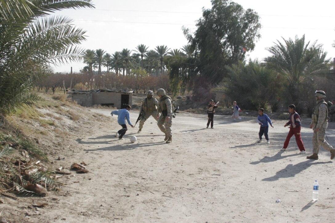 060117-M-2607O-001 - Marines from 3rd Squad, 2nd Platoon, Company F, 2nd Battalion, 2nd Marine Regiment, play soccer with the local kids in a village they are patrolling on Jan. 17.