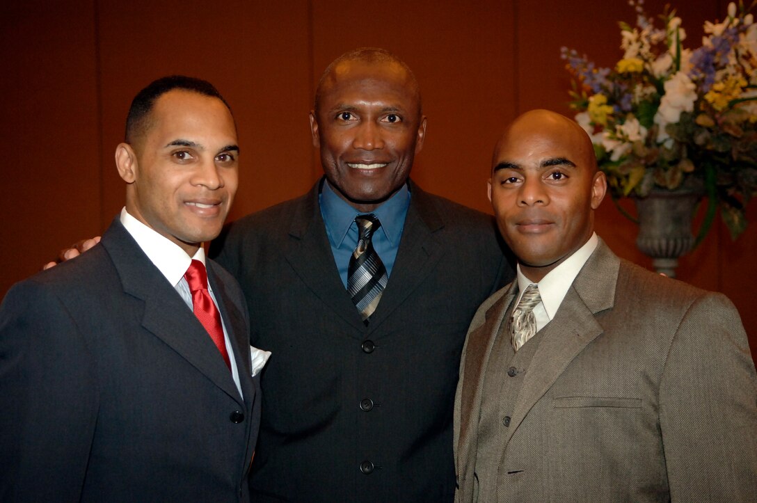 With more than 40 years of service between them, brothers Master Gunnery Sgt. William Farr, left, and Sgt. Maj. Dwayne Farr, right, pose with Sergeant Major of the Marine Corps, Sgt. Maj. John L. Estrada,  during a dinner banquet aboard Marine Corps Base Quantico, Va.  The Farrs are assigned to the same command for the first time in their careers. The Farr brothers are confident they will help the Recruiting Command meet its national recruiting goal for fiscal year 2006.  They will provide the necessary support to the Marine recruiters on the streets of America who talk with young men and women about the opportunities in the Marine Corps.