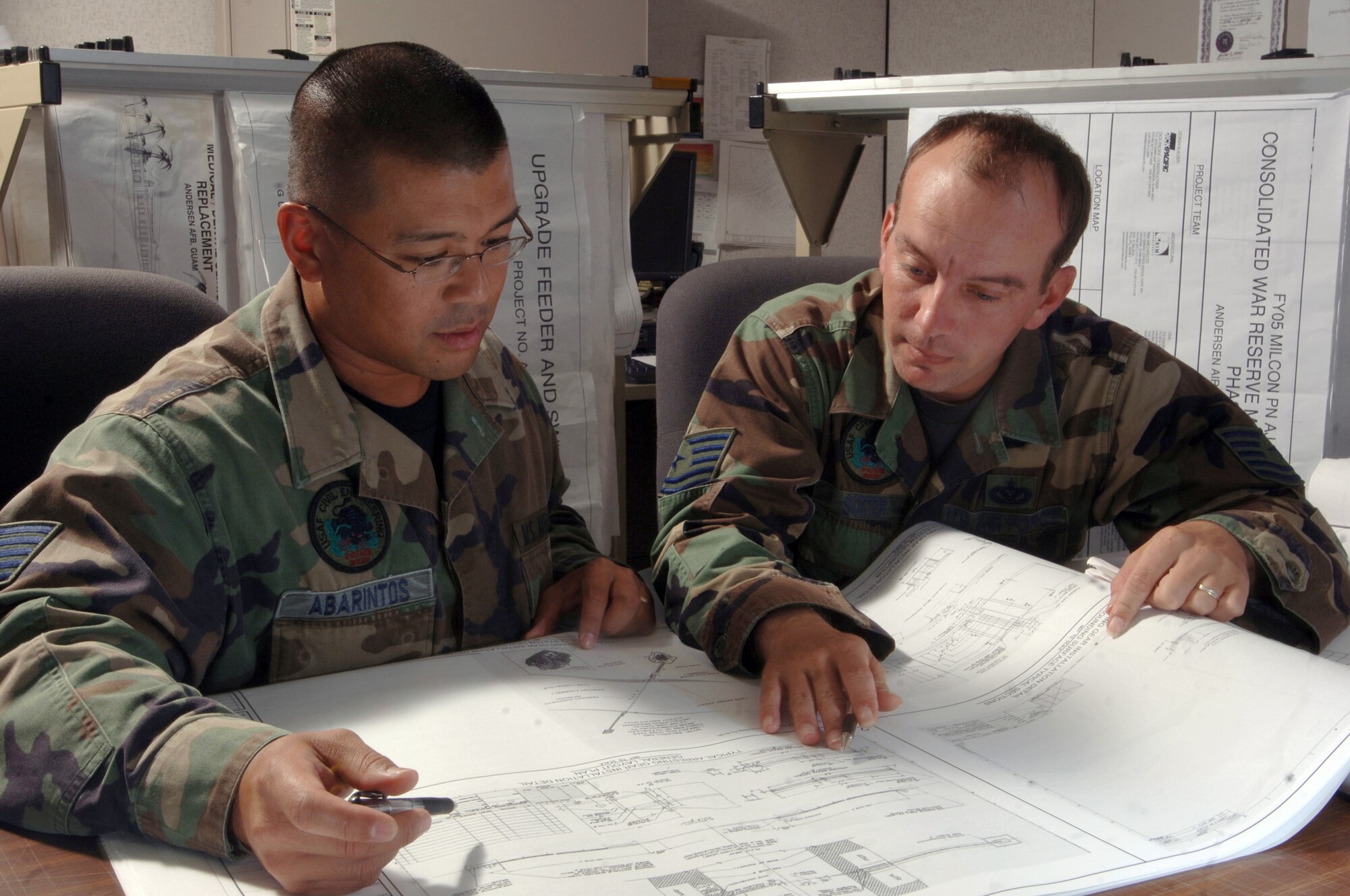 ANDERSEN AIR FORCE BASE, Guam (AFPN) -- Tech. Sgts. Gio Abarintos (left) and Chris Sorter review the design of a $24-million runway repair project at their facility here. The Airmen are engineering specialists with the 36th Civil Engineer Squadron. They provide day-to-day mission support to military and civilian personnel and 15 associate units here. They also maintain expeditionary capability for Air Force missions deploying to, originating from and transiting through the base. (U.S. Air Force photo by Master Sgt. Val Gempis)