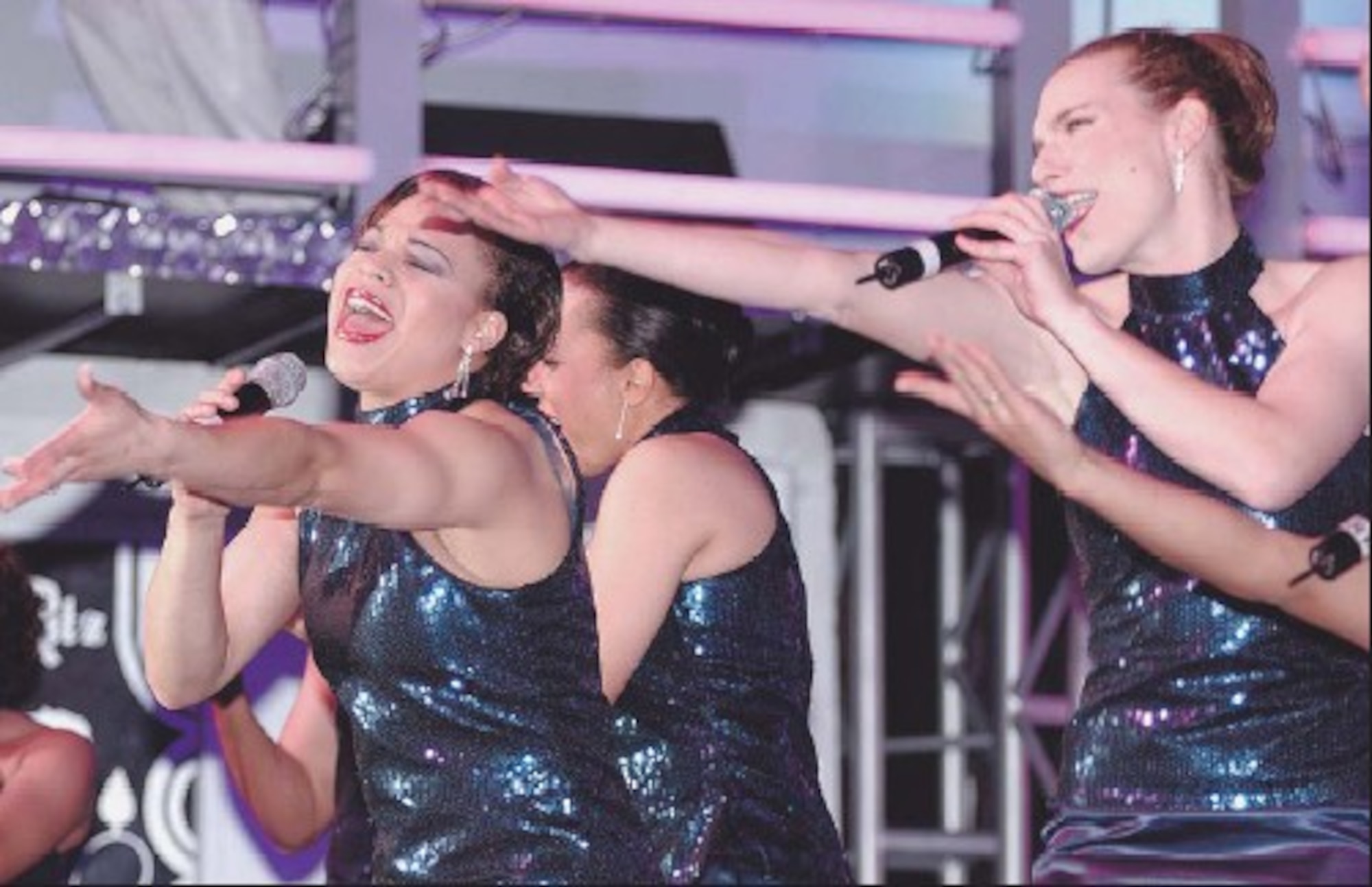 Senior Airman Erika Placencia, Buckley Air Force Base, Colo., (left) and 1st Lt. Tamilyn Becker, Hanscom Air Force Base, Mass.,(right) perform on stage during the 2005 Tops In Blue world tour Dec. 7 in the Freedom Hangar. Tops In Blue is an all active duty U.S. Air Force special unit made up of amateur performers selected for their entertainment abilities.