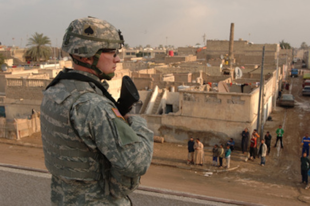 Army Staff Sgt. Clarence Hutton watches an intersection in Sadr City, Iraq, as he provides security for other soldiers on Jan. 12, 2006. Hutton is attached to the Army's 4th Brigade Combat Team, 101st Airborne Division, deployed to Iraq from Fort Campbell, Ky. 