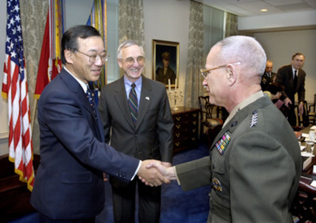 Deputy Secretary of Defense Gordon England (center) introduces Assistant Commandant of the Marine Corps Gen. Robert Magnus (right) to Japanese Minister of Finance Sadakazu Tanigaki (left) in the Pentagon on Jan. 13, 2006. Tanigaki met with England, Secretary of Defense Donald Rumsfeld and other senior officials. 