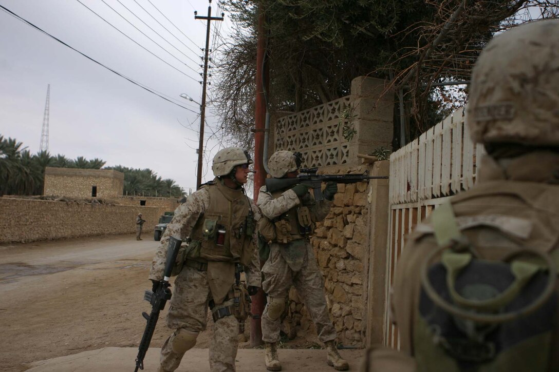 BARWANA, Iraq (Jan. 18, 2006) -A team of Marines with Company L, 3rd Battalion, 1st Marine Regiment prepare to breach a gate while clearing houses in Operation Red Bull II Jan. 18. The Marines along with Iraqi Army soldiers cleared houses and searched for weapons caches to rid the Triad area of insurgent operations. (Official Marine Corps photo by Cpl. Adam C. Schnell)
