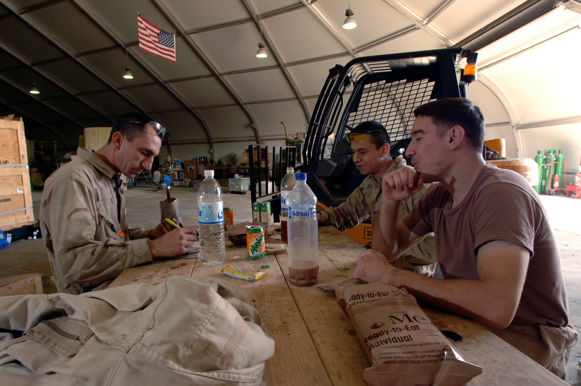 BALAD AIR BASE, Iraq (AFPN) - (From left) Senior Airman Marc Webber and Airmen 1st Class Juan Lopez and Jose Maneiro take a lunch break after a morning of fast-paced work installing up-armor kits. They are assigned to the 732nd Expeditionary Logistics Squadron here. The unit comprises active duty and Reserve component vehicle maintainers who support the Army Field Support Battalion-Iraq. The add-on armor shop will shut down operations this month. To date the shop's Airmen have up-armored more than 1,300 vehicles. (U.S. Air Force photo by Master Sgt. Lance Cheung)