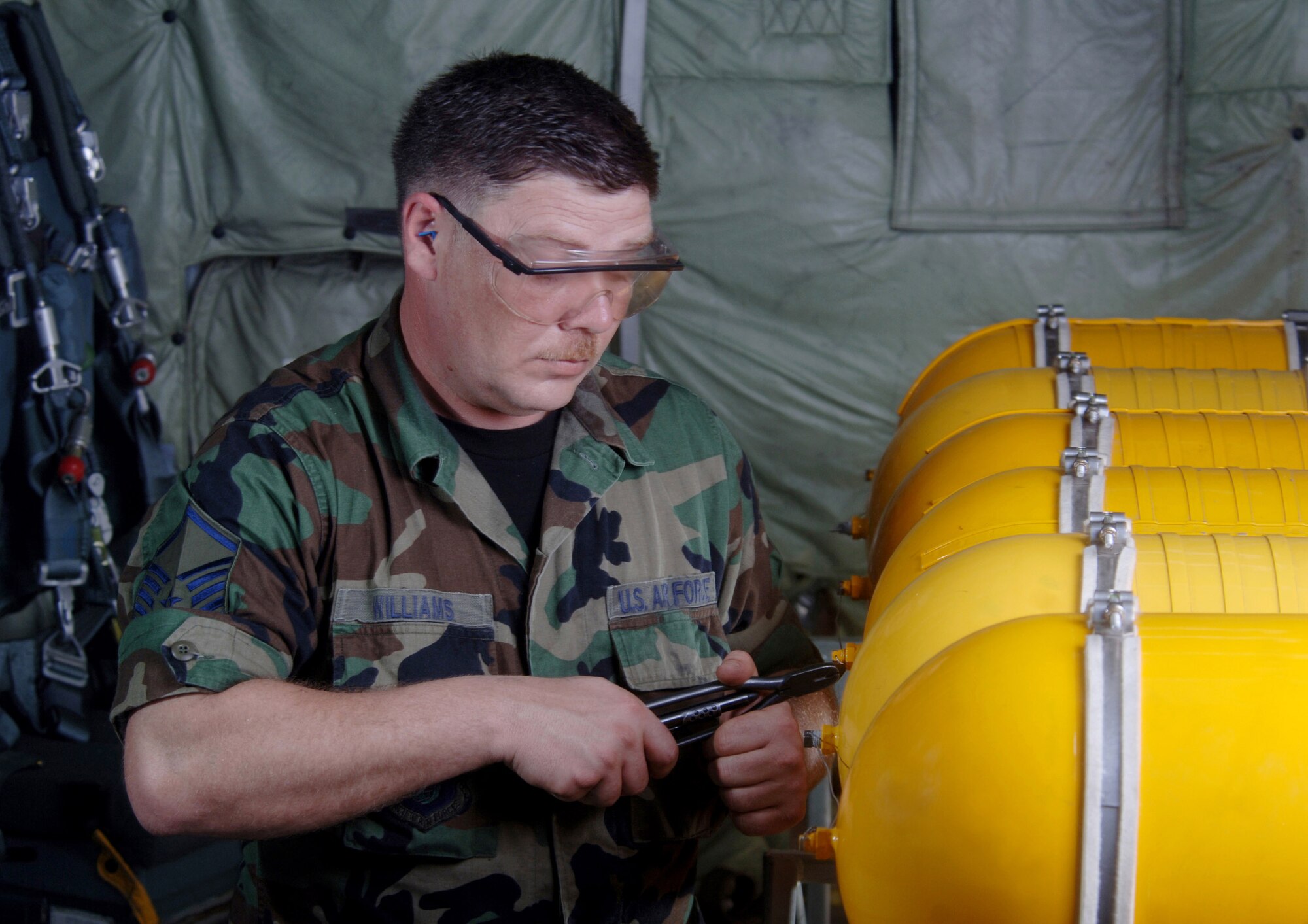 ANDERSEN AIR FORCE BASE, Guam (AFPN) -- Master Sgt. Mike Williams tightens a safety wire on oxygen bottles inside a KC-135 Stratotanker during an inspection here. Sergeant Williams is a crew chief with the 168th Air Refueling Wing of the Alaska Air National Guard at Eielson Air Force Base. The wing trains and equips KC-135R crews to provide air refueling in support of worldwide taskings. (U.S. Air Force photo by Master Sgt. Val Gempis)
