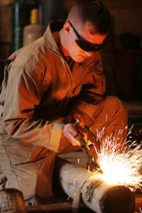 A U.S. Marine Corps engineer uses a cutting torch to cut a steel pipe as he fabricates support structures in Camp Fallujah, Iraq, on Jan. 12, 2006. The engineer is attached to the II Marine Expeditionary Force, which is deployed to Iraq from Camp Lejeune, N.C. 