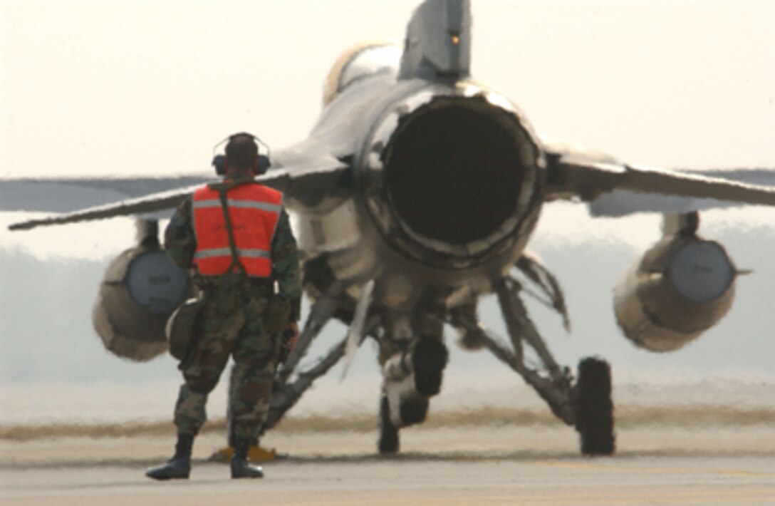 Air Force Master Sgt. Tracey Shook is bathed in the heat from the jet engine of an F-16 Fighting Falcon as he prepares to launch the aircraft from Shaw Air Force Base, S.C., on Jan. 13, 2006. Shook is attached to the 77th Aircraft Maintenance Unit. 