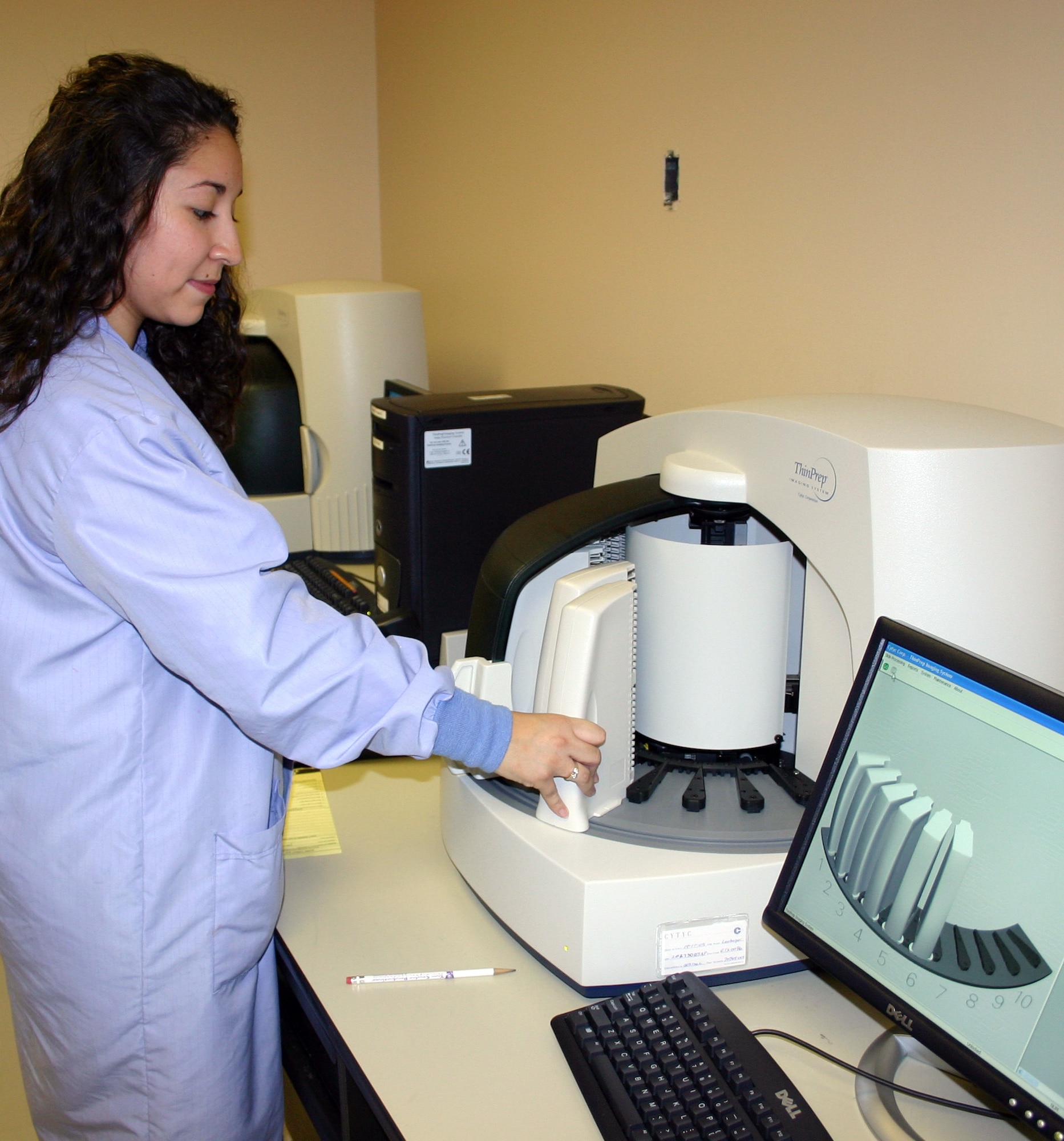 LACKLAND AIR FORCE BASE, Texas (AFPN) -- Cytology technician Roxanne Toscano loads slide racks into the new computer-enhanced digital imager. The new technology uses computer-assisted imaging and will increase productivity by 65 to 75 percent. It will allow the Air Force to combine the seven current cytology centers into one center here at Wilford Hall Medical Center's 859th Diagnostics and Therapeutics Squadron. (U.S. Air Force photo by Master Sgt. Kimberly Spencer)