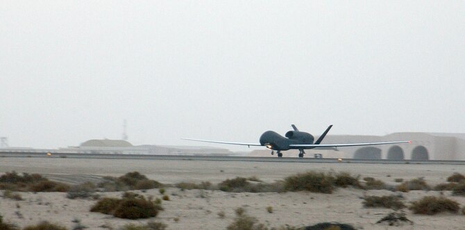 The Air Force's second deployed production Global Hawk lands on the runway of this undisclosed desert air base yesterday Jan. 12.  The arrival of two Global Hawk unmanned aerial vehicles marked the first deployment of the asset's production model; previous Global Hawks were prototype, or test models.  (Air Force photo by Tech. Sgt. Mike Hammond)
