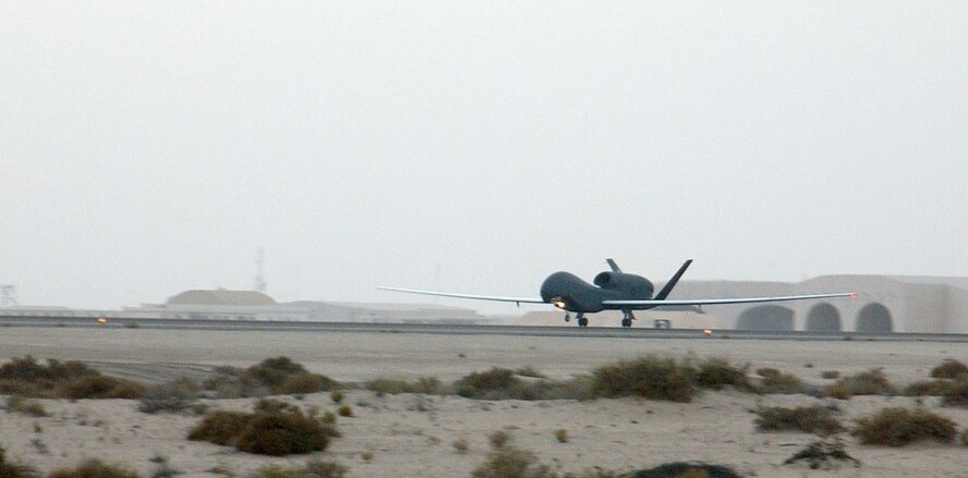 The Air Force's second deployed production Global Hawk lands on the runway of this undisclosed desert air base yesterday Jan. 12.  The arrival of two Global Hawk unmanned aerial vehicles marked the first deployment of the asset's production model; previous Global Hawks were prototype, or test models.  (Air Force photo by Tech. Sgt. Mike Hammond)
