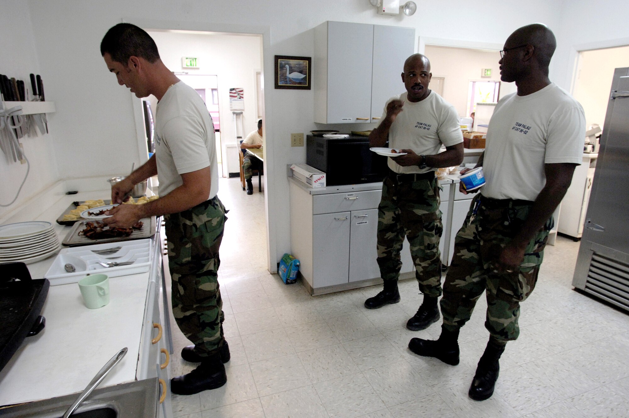 BABLEDAOB, Palau (AFPN) -- Tech. Sgts. Jamie Pahukoa and Frank Strong and Master Sgt. Wesley Matthews get their breakfast before starting the day. The three are with the Palau civil action team.  The mission of the program is twofold.  It aids host nations in their basic infrastructure development and provides a favorable U.S. military presence through community construction, apprentice training, a medical civic action program and community relations. (U.S. Air Force photo by Tech. Sgt. Shane A. Cuomo)