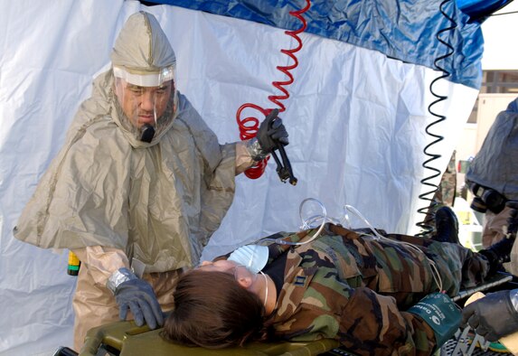 MACDILL AIR FORCE BASE, Fla. (AFPN) -- Capt. Rebecca Ford gets decontaminated by a member of the 6th Medical Operations Squadron decon team after a mock chemical attack Jan. 18 here.  The decon team has eight to 10 members.  The tent takes approximately 12 minutes or less to set up. (U.S. Air Force photo by Airman 1st Class Bradley A. Lail)