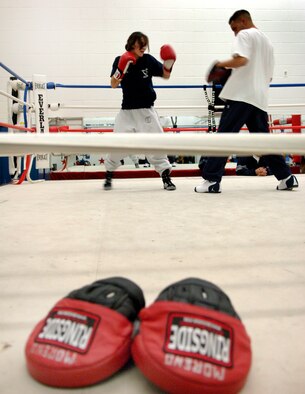 SAN ANTONIO (AFPN) -- Senior Airman Celsa Reyes throws punches during simulated rounds while Staff Sgt. Steven Franco, assistant coach, instructs at the Air Force Boxing Training Camp here. Twenty-four Airmen are trying out for the nine spots to represent the Air Force at the Armed Forces Tournament.  (U.S. Air Force photo by Tech. Sgt. Larry A. Simmons)
