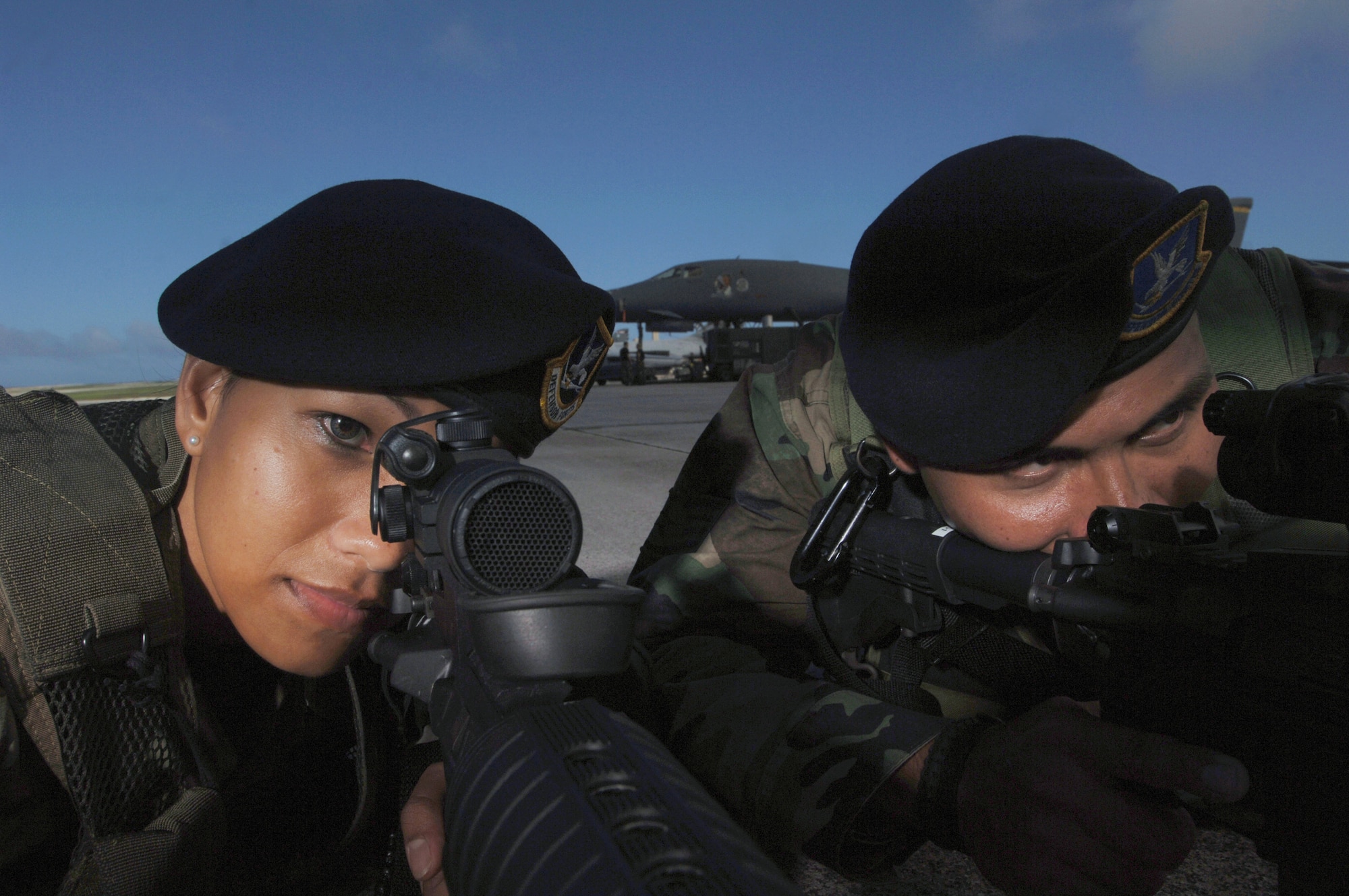 ANDERSEN AIR FORCE BASE, Guam (AFPN) -- Senior Airman Maria Ronquillo and Staff Sgt. Michael Quitugua look out for enemy forces during training at the flightline here. Both Airmen are assigned to the Guam Air National Guard's 254th Security Forces Squadron. The guardsmen help the wing's active-duty 36th SFS maintain their mission by augmenting for their deployed troops here. (U.S. Air Force photo by Master Sgt. Val Gempis)