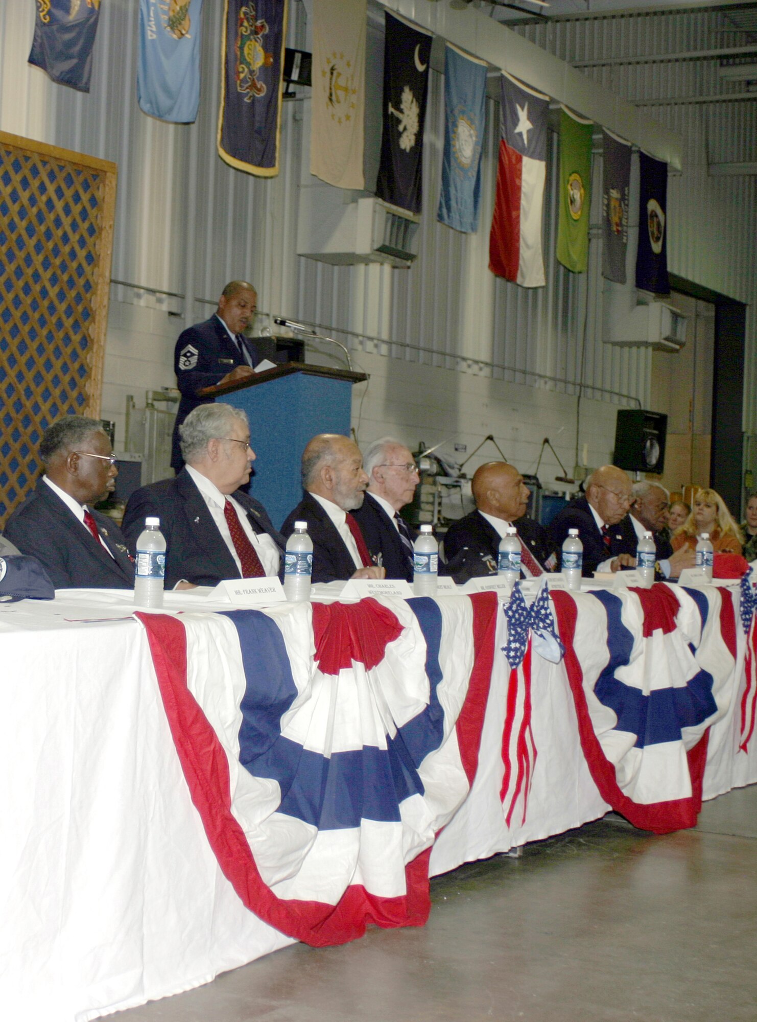 WRIGHT-PATTERSON AFB, Ohio -- Senior Master Sgt. Joseph Smith, at the podium, addresses a crowd of reservists and special guests during the Tuskegee Airmen event held Nov 5.  Ten orginial Tuskegee Airmen were honored during the 445th Airlift Wing's Unit Training Assembly.  Several of the honored guests told stories concerning their military careers.  Wing members had the opportunity to speak to the airmen and get autographs after the ceremony.  (Photo by MSgt. Doug Moore)
