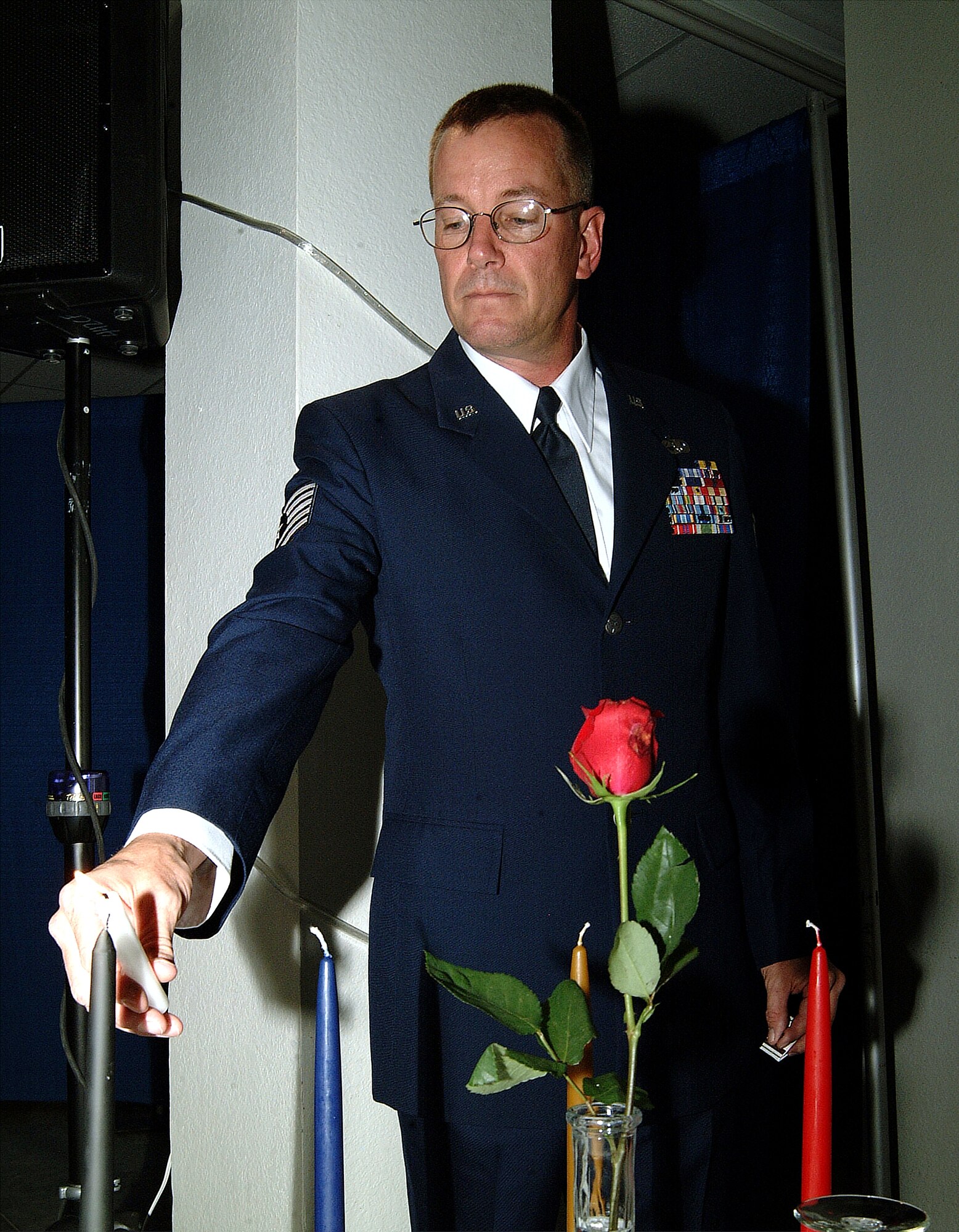 Tech. Sgt. Paul Hanson, from the 442nd Aircraft Maintenance Squadron, an Air Force Reserve unit at Whiteman Air Force Base, Mo., lights a candle for a POW and MIA remembrance at the start of "Hogfest 2005," the annual 442nd Maintenance Group's awards ceremony Nov. 5, 2005.