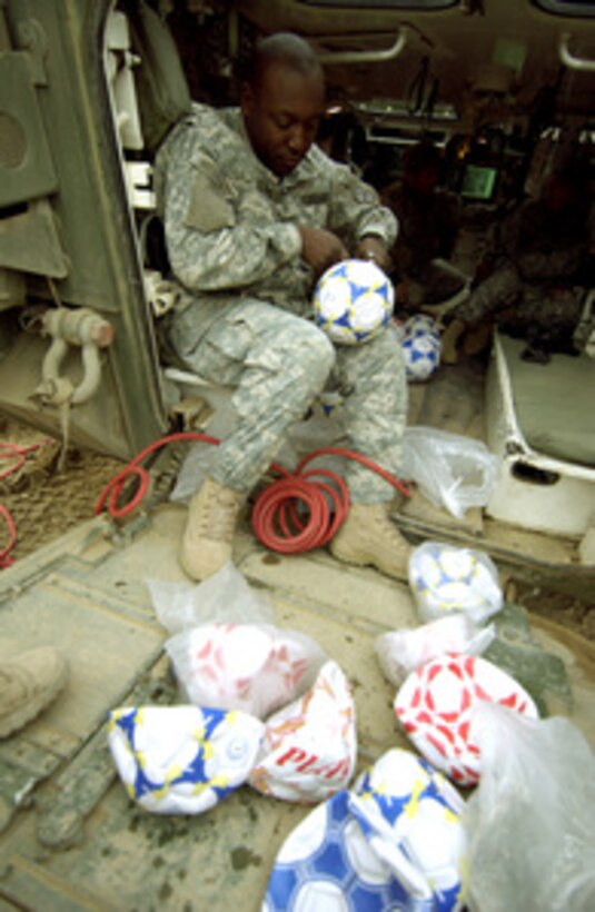 Staff Sgt. Philander Kerry inflates soccer balls before a mission in Mosul, Iraq, on Jan. 18, 2006. Kerry, and his fellow soldiers from the U.S. Army's Alpha Company, 2nd Battalion, 1st Infantry Regiment, 172nd Stryker Brigade, will pass out the donated soccer balls to Iraqi children while on patrol in Mosul. 