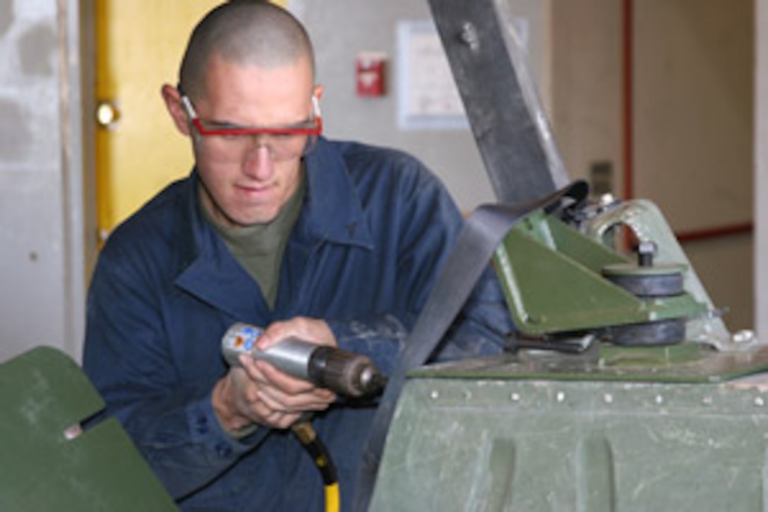 Lance Cpl. Steven Villa, a 19-year-old engine mechanic with 1st Maintenance Battalion, 1st Marine Logistics Group, drills holes into the body of a humvee at the Combat Center's Exercise Support Division motor pool Feb. 20.