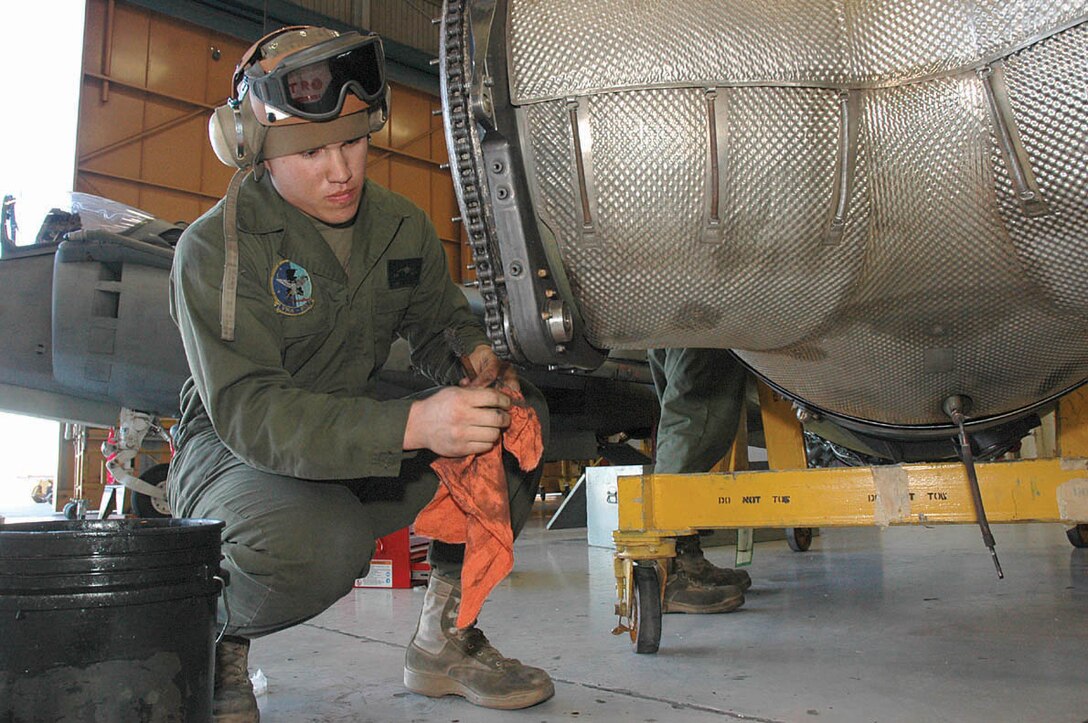 Cpl. Daniel D. Petrosky, Marine Attack Squadron 513 powerline mechanic and native of Rose Hill, Kan., lubricates hotnozzle raceways on an AV-8B Harrier II engine during an engine change Friday at VMA-513?s hangar. With VMA-513 deploying to Iraq in February, operational readiness has become an increasingly important part of the daily routine.