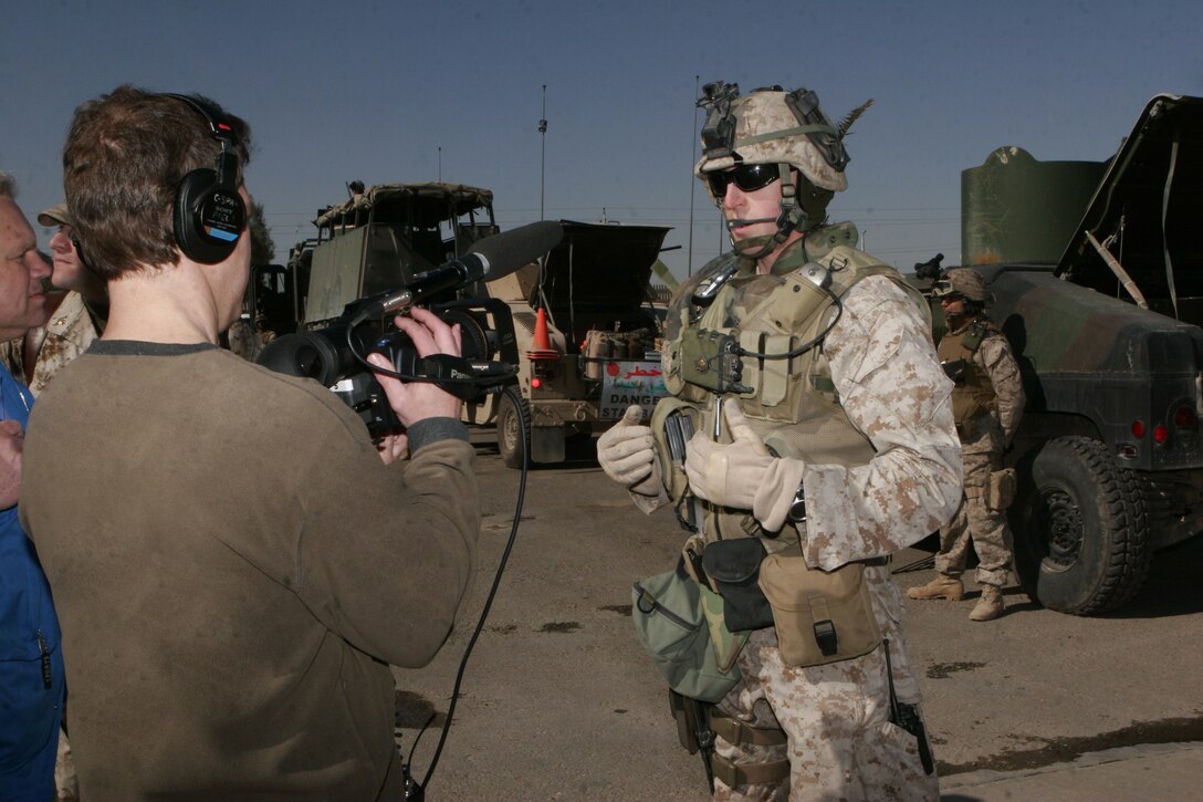 Fully-geared 1st Lt. Frank Cardamone, convoy commander, II Marine Expeditionary Force, Headquarters Group, II MEF (FWD), demonstrates the equipment Marines wear during convoys to members of the media during a congressional delegation visit aboard Camp Fallujah on Jan. 21.  The visit allowed congress members to visit with Marines here to see their daily lives.