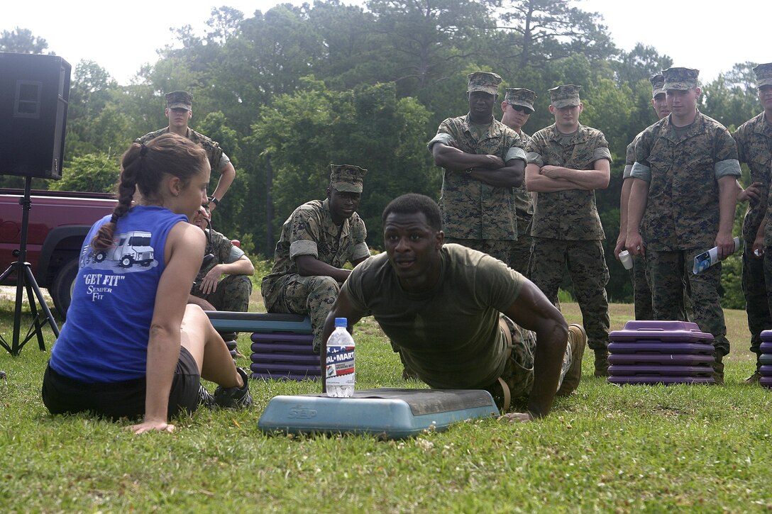 MARINE CORPS BASE CAMP LEJEUNE, N.C. (June 22, 2006) - A Marine with 3rd Battalion, 10th Marine Regiment showcases his push-up skills before fellow Marines and the Semper Fit girls during a hydration awareness presentation here June 22.  This event was part of the annual 2nd Marine Division summer safety fair, during which troops visited with a variety of Marine leaders, local law enforcement officials and civilian vendors to get educated on summertime safety risks such as fire prevention, proper hydration and recreational vehicle safety.
