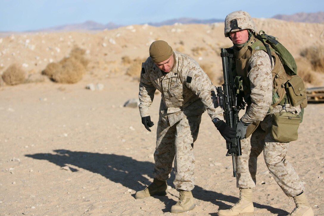Sgt. Gregory J. Zieba, platoon sergeant for Company I, 3rd Battalion, 8th Marine Regiment shows Lance Cpl. Brent R. Boek, team leader for 1st Platoon, Company I, 3rd Bn, 8th Marines how to properly pivot to face a target during a  demonstration of marksman ship techniqies. 3rd Bn., 8th Marines are conducting the Mojave Viper training at Twentynine Palms Calif. the unit will deploy in support of Operation Iraqi Freedom in March.