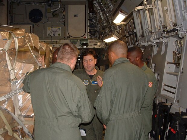 Charleston AFB, SC -  Maj Keith Moore, 315th Airlift Wing's Current Operations Officer and command C-17 pilot, briefs RAVEN team on specifics of recent mission 
"down south". (photo by Chief Master Sgt. Charlie Hall, USAFR)