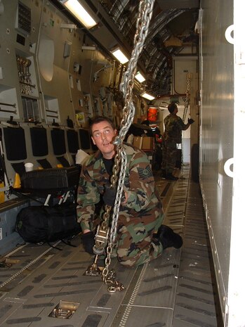 Charleston AFB, SC - TSgt Vaughn Mangum, a reservist with the 315th Airlift Wing's 81st APS,  checks tiedowns on heavy uploads during training mission. (photo by Chief Master Sgt. Charlie Hall, USAFR)