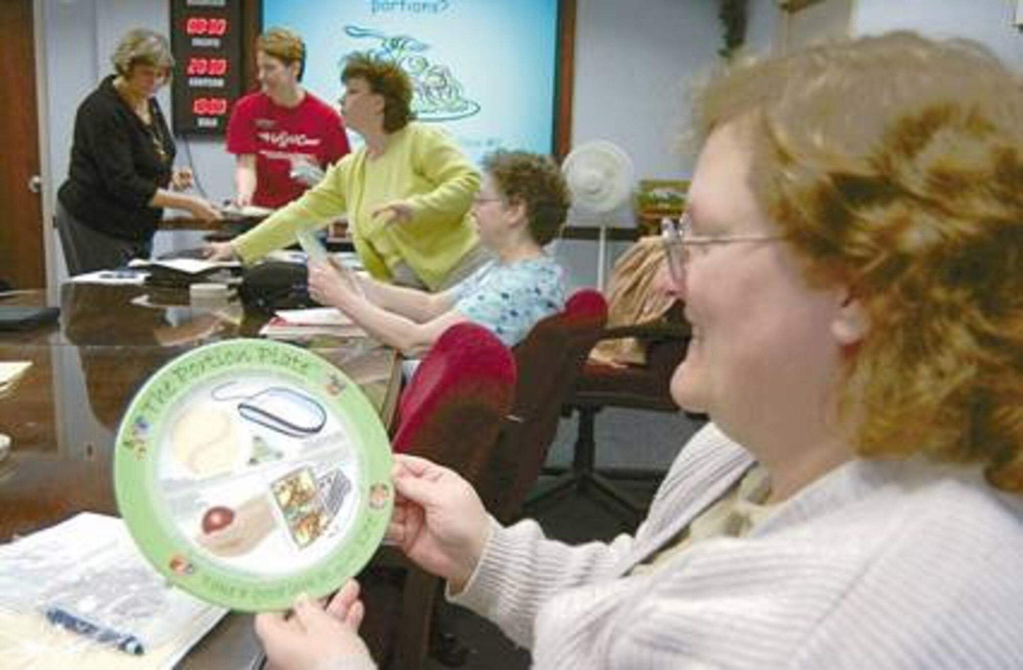 Terry Bohannon holds a "portion plate" Jan. 17 as the weight reduction class, Portion off the Pounds, begins.
