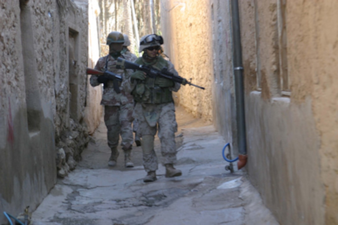 Marine Lance Cpl. Eliot Yarmura leads Iraqi Army soldiers through an alleyway as they conduct a security patrol through the streets of Barwana, Iraq, on Jan. 15, 2006. The Marine and Iraqi soldiers are looking for signs of anti-coalition activity in Barwana. Yarmura is attached to Lima Company, 3rd Battalion, 1st Marine Regiment. 