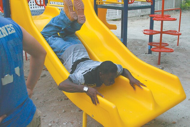 Navy Airman Keith Stanton, an aviation electrician with Marine Aviation Logistics Squadron 31, ?tests? a slide at the Baptist Church of Beaufort playground Saturday, June 24. Stanton and other Stingers from MALS-31 have spent every Saturday for the past month and a half volunteering their time to build a playground for the church.