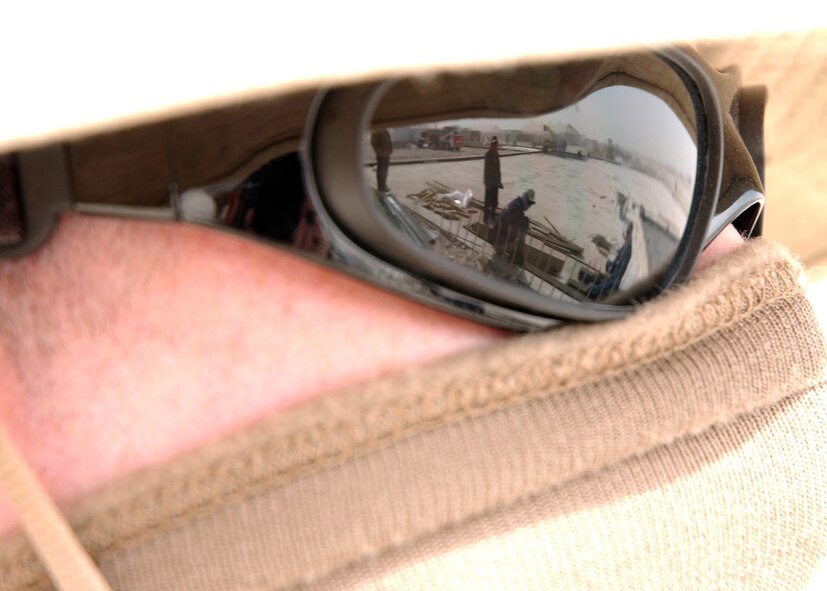 SOUTHWEST ASIA (AFPN) -- Airman 1st Class Benjamin Riley watches third country national contractors build a new structure at a deployed location on Jan. 22. Airman Riley is a third country national escort with the 379th Expeditionary Civil Engineer Squadron, deployed from Barksdale Air Force Base, La. (U.S. Air Force photo by Staff Sgt. Joshua Strang)