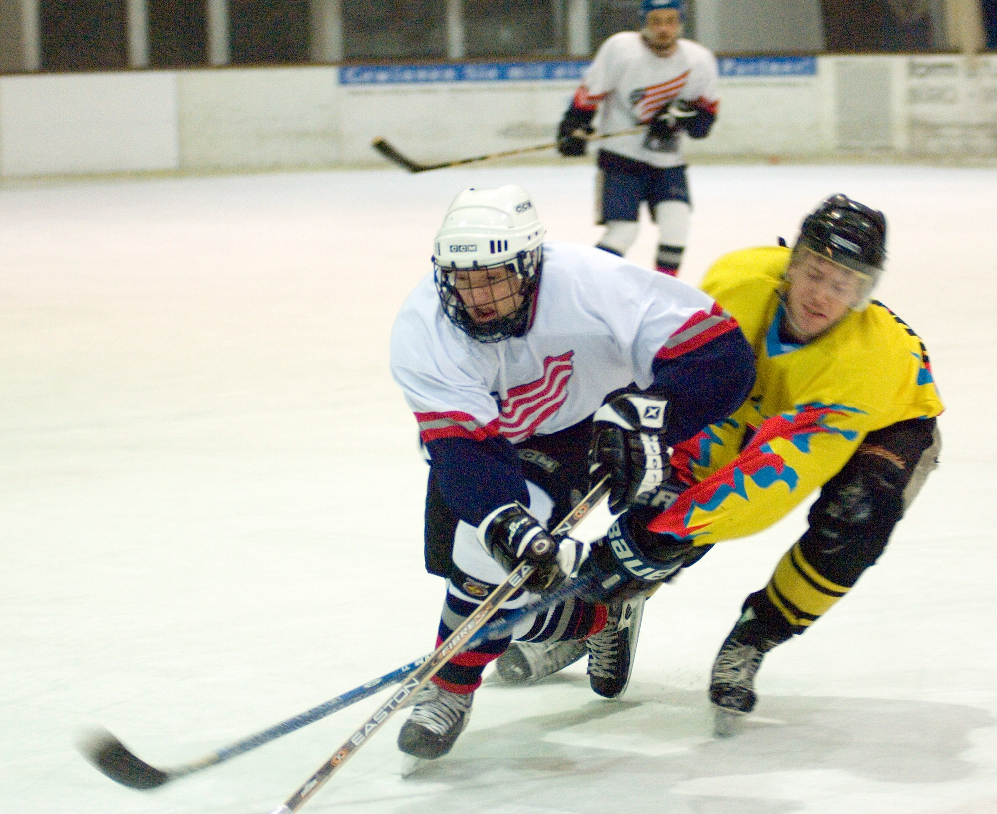 EPPELHEIM, Germany (AFPN) -- Capt. Kris Uber (left) races to the puck against a player from the Eppelheim Hawks. The KMC Eagles won 6-4. The Kaiserslautern Military Community hockey team is made up of 30 players in different skill levels varying from semi-pro and college to players experiencing their first organized game. Captain Uber is with the 76th Airlift Squadron at Ramstein Air Base, Germany. (U.S. Air Force photo by Master Sgt. John E. Lasky)