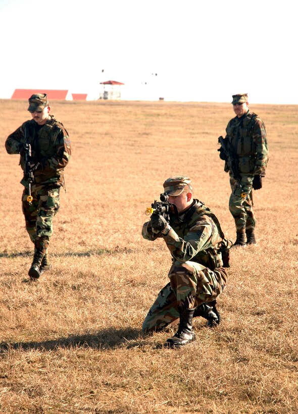 908th Security Forces Squadron members Senior Airmen Christopher Pike and Christopher Moore move into firing positions with their new M4 Rifles while Tech. Sgt. Steve Higginbotham gives instructions during a practice patrol mission at the Blue Thunder Field Training Complex, Maxwell AFB, Ala.  After nearly three years of waiting, the Air Force Reserve Command unit received new M4 carbines, replacing the M-16A2 rifles that have been in the units inventory since 1994. (Photo by Jeffery Melvin, 908th Airlift Wing Public Affairs (AFRC), Maxwell AFB, Ala.)