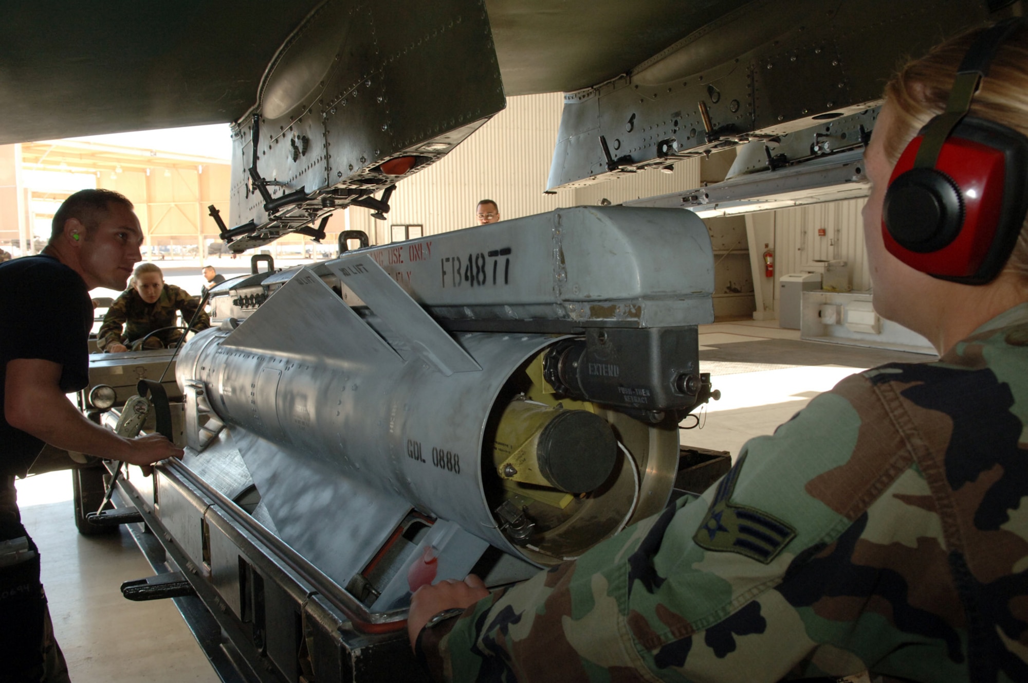 DAVIS-MONTHAN AIR FORCE BASE, Ariz. (AFPN) -- Crew Chief Staff Sgt. Patrick Dull, along with his team members Senior Airmen Amber Dittmer and Jennifer Martin line up the suspension lugs on a Maverick missile to ensure it will lock into place properly for transportation and than release at target site.  The three Airmen are assigned to the 355th Aircraft Maintenance Squadron, which is comprised of the 354th, 357th and 358th Aircraft Maintenance Units. The 357th AMU placed first and completed the load in 38 minutes and 44 seconds.  (U.S. Air Force photo by Staff Sgt. Lanie McNeal)