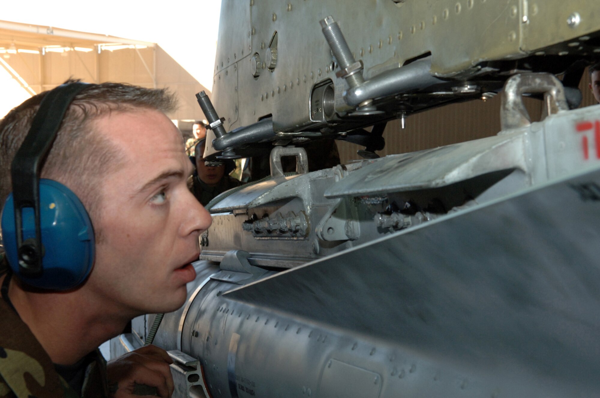 DAVIS-MONTHAN AIR FORCE BASE, Ariz. (AFPN) -- Staff Sgt. Paul Retherford performs an eyeball test to ensure that the suspension lugs are aligned on the bomb rack enabling the bomb to be locked on to the A-10 Thunderbolt II.  Sergeant Retherford is a crew chief with the 355th Aircraft Maintenance Squadron, which is comprised of the 354th, 357th and 358th Aircraft Maintenance Units. The 357th AMU placed first and completed the load in 38 minutes and 44 seconds.  (U.S. Air Force photo by Staff Sgt. Lanie McNeal)