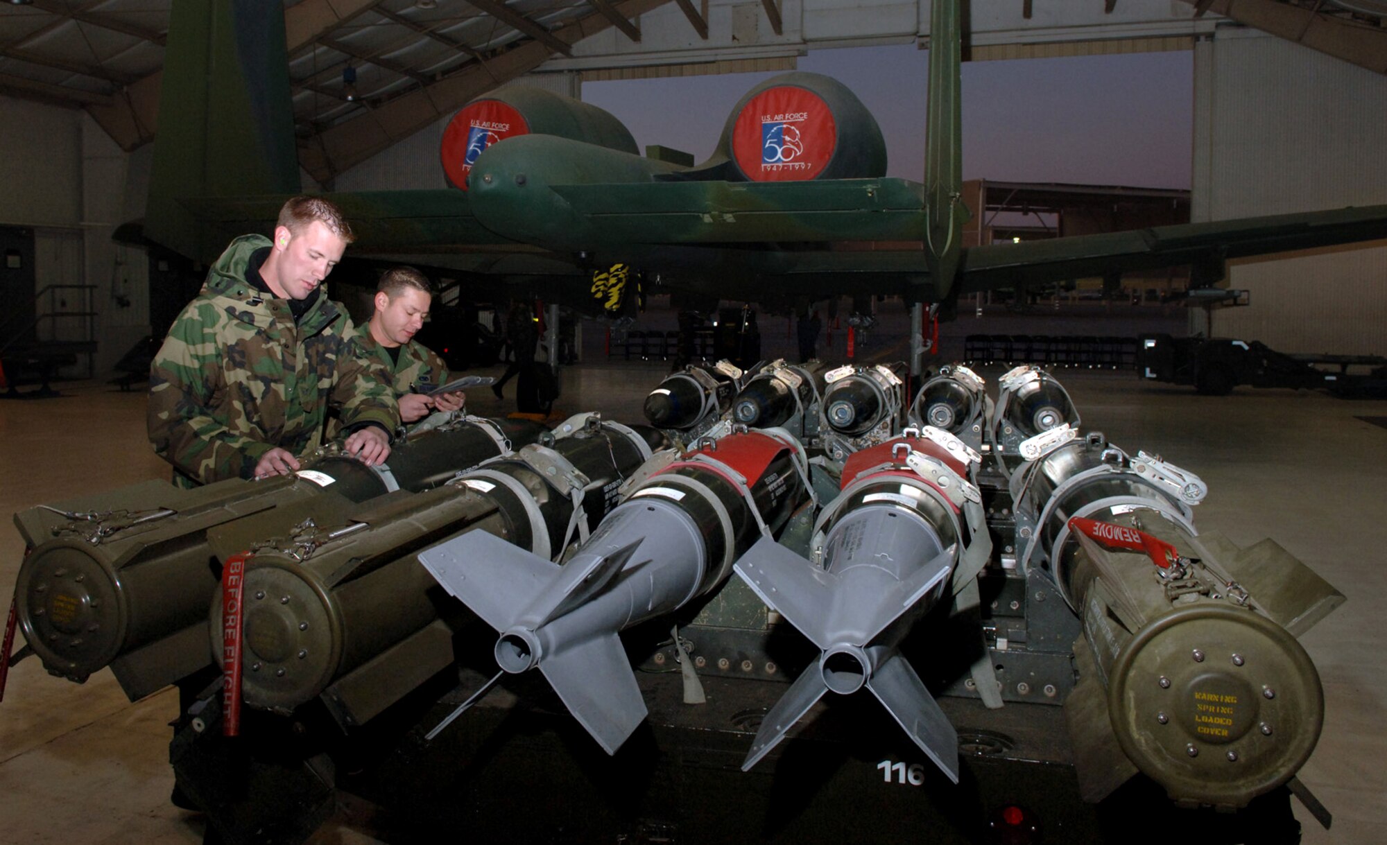 DAVIS-MONTHAN AIR FORCE BASE, Ariz. (AFPN) -- Senior Airman Thomas Dougherty (foreground) and Staff Sgt. Luis Heredia go over their checklists to ensure  bombs are serviceable before loading them onto the awaiting A-10 Thunderbolt during a load crew competition.  Both Airmen are assigned to the 355th Aircraft Maintenance Squadron.  The 355th AMXS is comprised of the 354th, 357th and 358th Aircraft Maintenance Units. The 357th AMU placed first and completed the load in 38 minutes and 44 seconds.  (U.S. Air Force photo by Staff Sgt. Lanie McNeal)