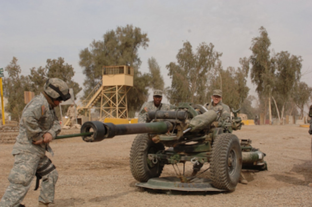 Pfc. Christian Zelaya pushes a cleaning rod down the barrel of a towed howitzer during routine maintenance at Forward Operations Base Rustimya, Iraq, on Jan. 23, 2006. Zelaya is attached to the Army's Bravo Company, 4th Brigade, 320th Field Artillery Regiment, 101st Airborne Division. 