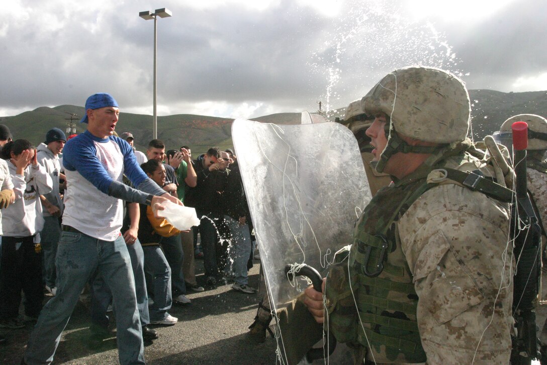 Cpl. David J. Huff, 11th Marine Expeditionary Unit, Battalion Landing Team 1st Battalion, 4th Marine Regiment, based out of Camp Pendleton, stands ready to repel a possible assault by a crowd of unruly protesters during a consulate security training exercise during Joint Task Force Exercise 06, Jan. 13-25 aboard the U.S.S. Peleliu and throughout Camp Pendleton.