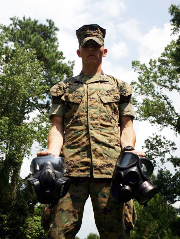 MARINE CORPS BASE CAMP LEJEUNE, N.C.(July 26, 2006)-Lance Cpl. Tim S. Pope, a fireteam leader with Company C, 1st Battalion, 2nd Marine Regiment demonstrates the differences between the XM-50 protective mask the M-40 field protective mask. The Marines were part of the U.S. Army Operational Test Command's testing of the XM-50 here, July 26. The purpose of these series of tests is to see if the mask is capable of replacing the current model and also provide a joint service general purpose mask.