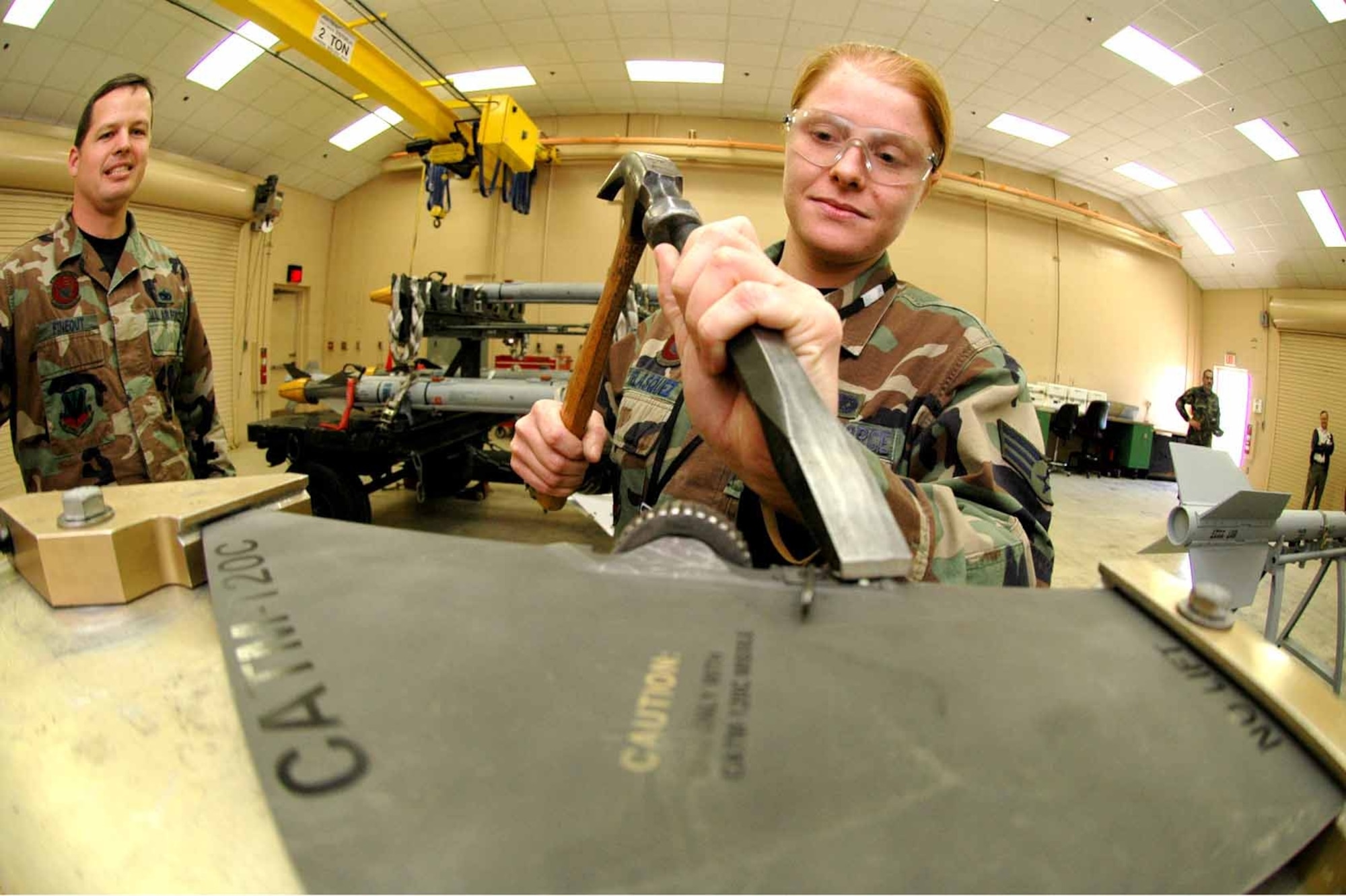 EGLIN AIR FORCE BASE, Fla. (AFMCNS) -Senior Airman Theresa Velasquez, 33rd Maintenance Squadron precision guided munitions crew member, removes a rivet on an AIM-120 fin using a fixture created by the Munitions Materiel Handling Equipment Focal Point here. Before the crew had this piece of equipment it could not change the locks and had to send the fin off for a depot-level repair. This process would have taken at least a month and now it is done in as little as one minute inside the shop.  (Air Force photo by Senior Airman Mike Meares)
