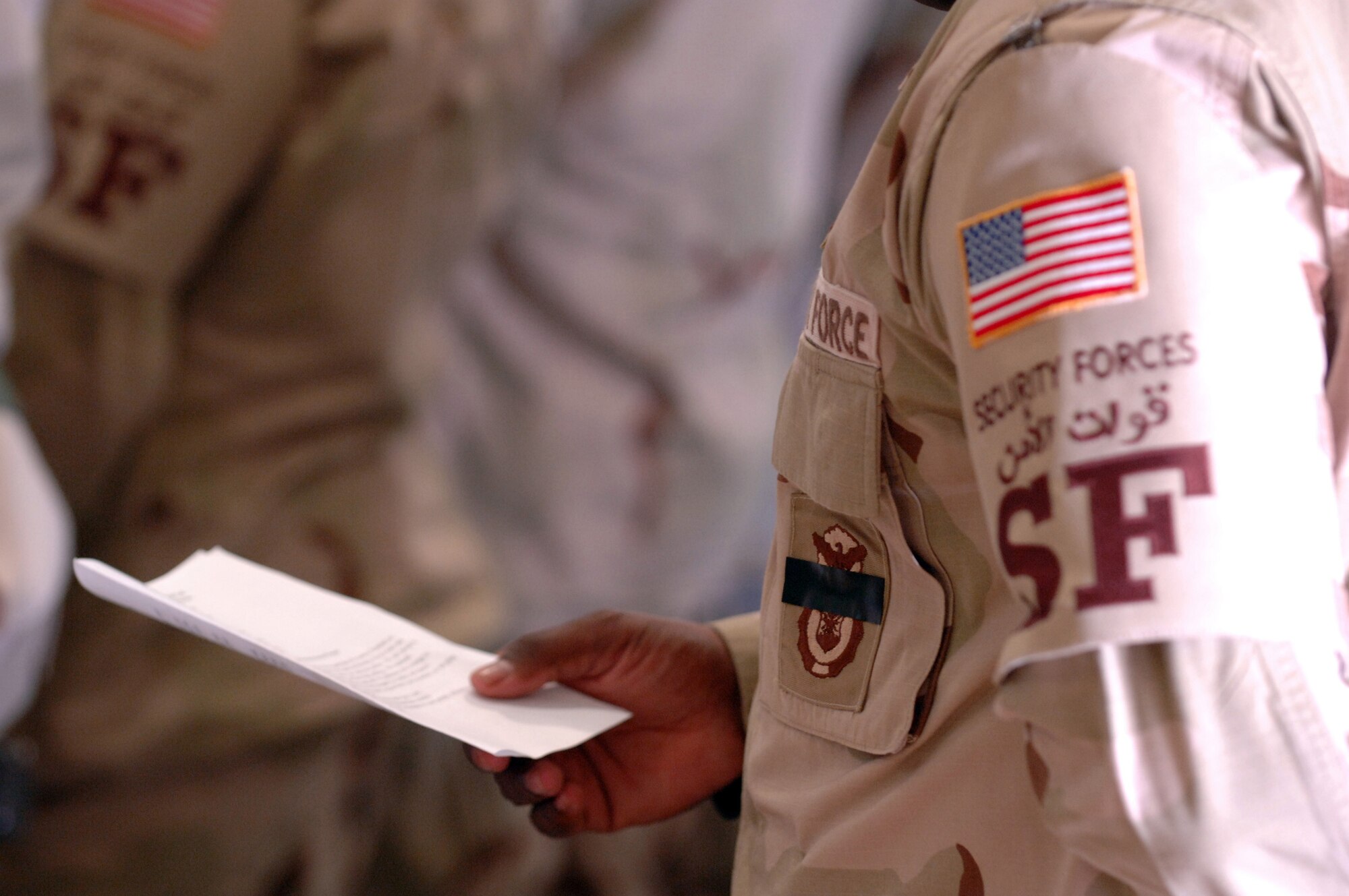 SOUTHWEST ASIA (AFPN) -- An Airman with the 379th Air Expeditionary Security Forces Squadron reads a passage during a memorial service Jan. 26 for two Airmen killed in action. Base security forces Airmen wore black tape across their badges as a sign of respect for the two Airmen -- Tech. Sgt. Jason L. Norton and Staff Sgt. Brian McElroy of Elmendorf Air Force Base, Alaska.  (U.S. Air Force photo by Staff Sgt. Joshua Strang)

