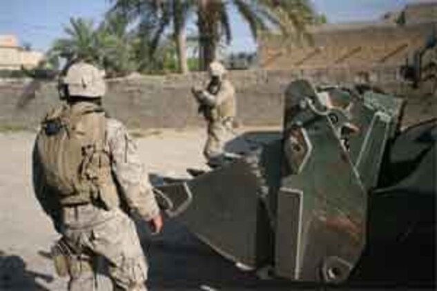Lance Cpl. Joshua J. Henderson (left) and Cpl. Travis J. Anderson (right) utilize an up-armored forklift, commonly referred to as a TRAM, to emplace over 300 concrete barriers at Combat Outpost Falcon June 26, 2006. Five Marines, a part of Combat Logistics Detachment 115, Combat Logistics Regiment 15, out of Camp Taqaddum, Iraq, aided the Army's 1st Brigade, 1st Armored Division in securing the combat outpost, a part of increased security operations in Southern Ramadi.