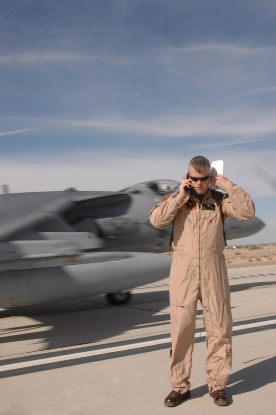 Capt. Ben Hutchins, Marine Attack Squadron 513 pilot training officer and native of Raleigh, N.C., listens to his radio over the scream of an AV-8B Harrier II passing behind him Jan. 26 on echo taxiway of the station flightline. Echo taxiway is being used by VMA-513 to simulate a taxiway sometimes used by Harrier pilots to land in Iraq, where they will soon be deploying to.