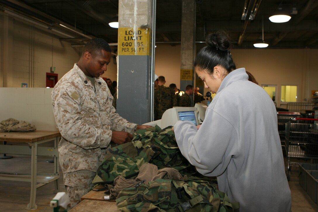 Sagrario Cienfuegos (right), store clerk, II Marine Expeditionary Force Consolidated Issue Facility, helps Staff Sgt. Darrion Kelley, radio supervisor, 2nd Transportation Support Battalion, 2nd Marine Logistics Group, return gear at the CIF issue point Jan. 26. Before Marines can check gear back into the CIF, they must have a check-out sheet and must clean all gear prior to arrival.