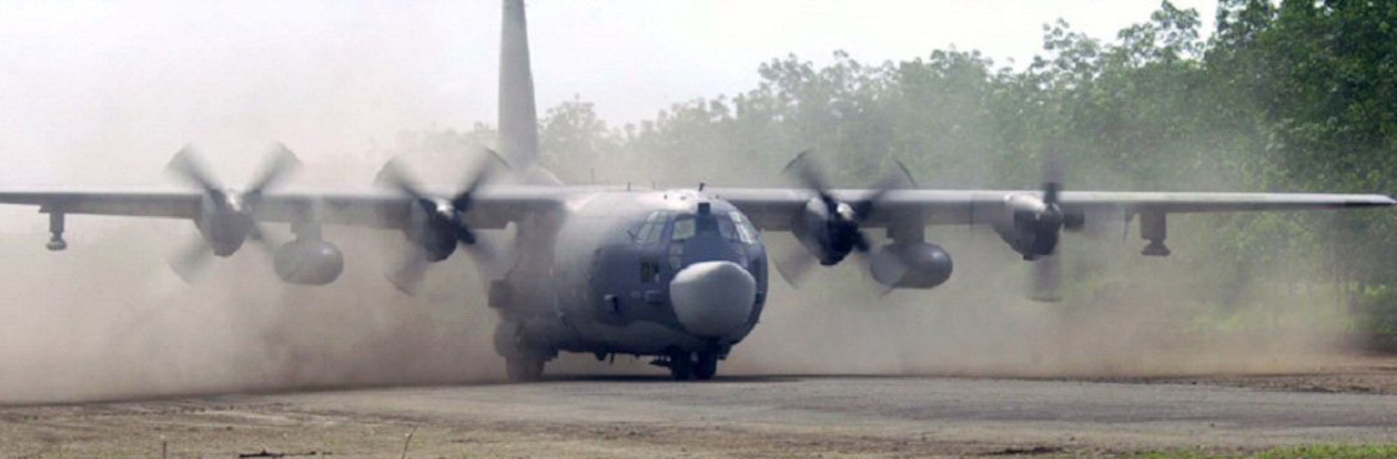 A MC-130 Combat Talon II from the 15th Special Operations Squadron lands on a dirt airfield.
