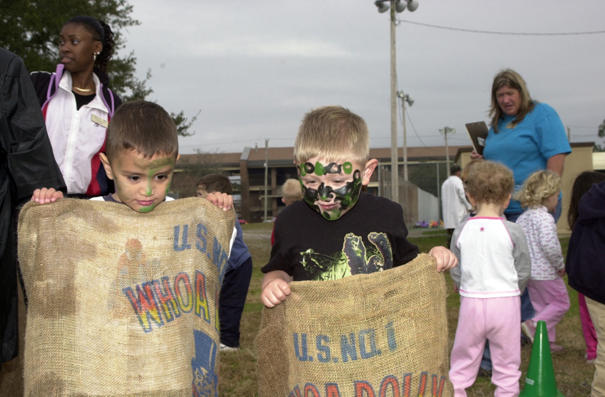 TYNDALL AIR FORCE BASE, Fla. (AFPN) -- Isaiah Lopez (left) and Ronin Davis manage one of the obstacle course challenges of hopping along in burlap bags. (U.S. Air Force photo by Master Sgt. Mary McHale)
