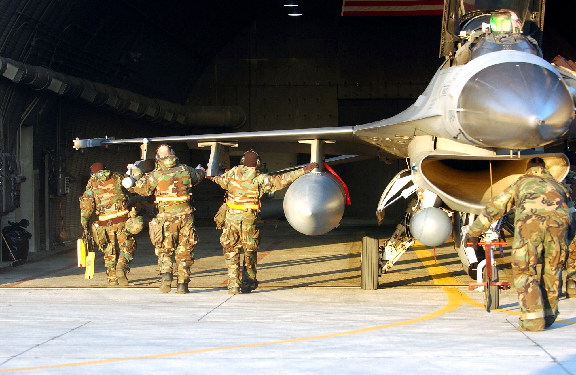 OSAN AIR BASE, South Korea (AFPN) -- Members of the 51st Maintenance Squadron push an F-16 Fighting Falcon back into a hangar after a mission supporting exercise Beverly Bulldog 06-01 here Jan. 24. Exercise scenarios test the base's ability to protect its operations from missile attacks or enemy forces. (U.S. Air Force photo by Airman Gina Chiaverotti)

